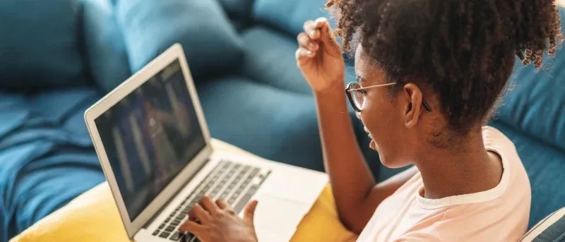 Teenager using a laptop at home